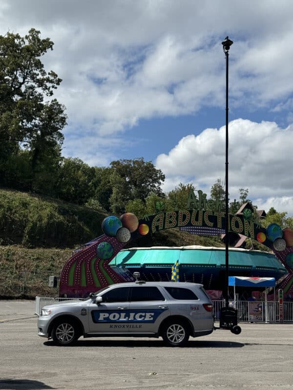 Knoxville Police Department vehicle with RATT RQ610 mobile surveillance tower deployed at a special event in front of the 'Abduction' ride.
