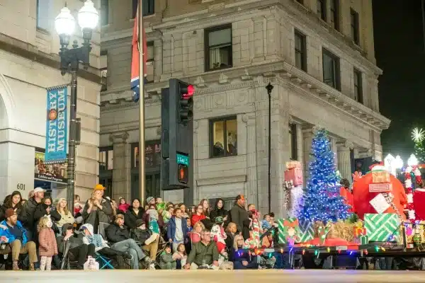 Surveillance tower next to Christmas parade float with giant snowman and spectators