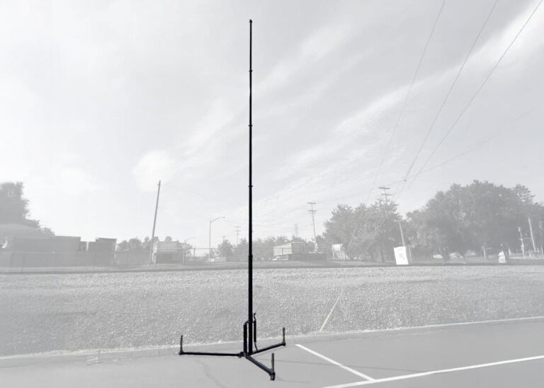 Tripod-Mounted Telescopic Mast for Rapid Field Deployment - Tech Deployments Made Simple by Critical Tech Solutions Grayscale image of tripod-mounted pneumatic telescopic mast extended in open terrain.