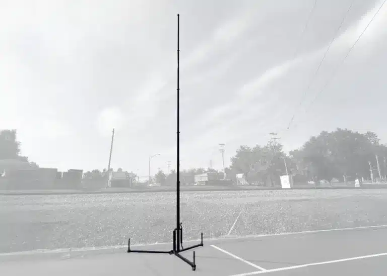 Tripod-Mount-grayscale-7x5-1 - Tech Deployments Made Simple by Critical Tech Solutions Grayscale image of tripod-mounted pneumatic telescopic mast extended in open terrain.