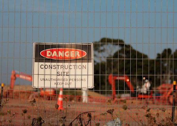 Danger sign on fence marking restricted access for construction site security