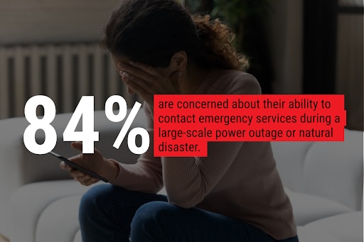 Person holding a phone and covering their face, showing stress during a power outage or disaster