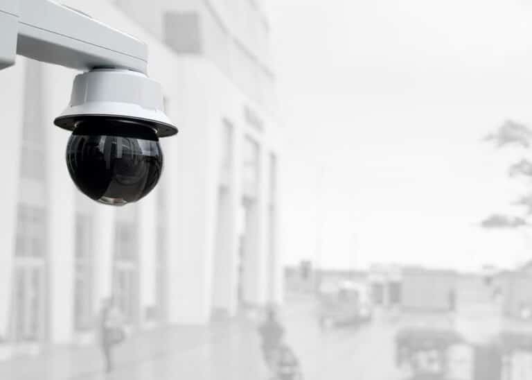 PTZ dome security camera mounted on exterior wall of commercial facility