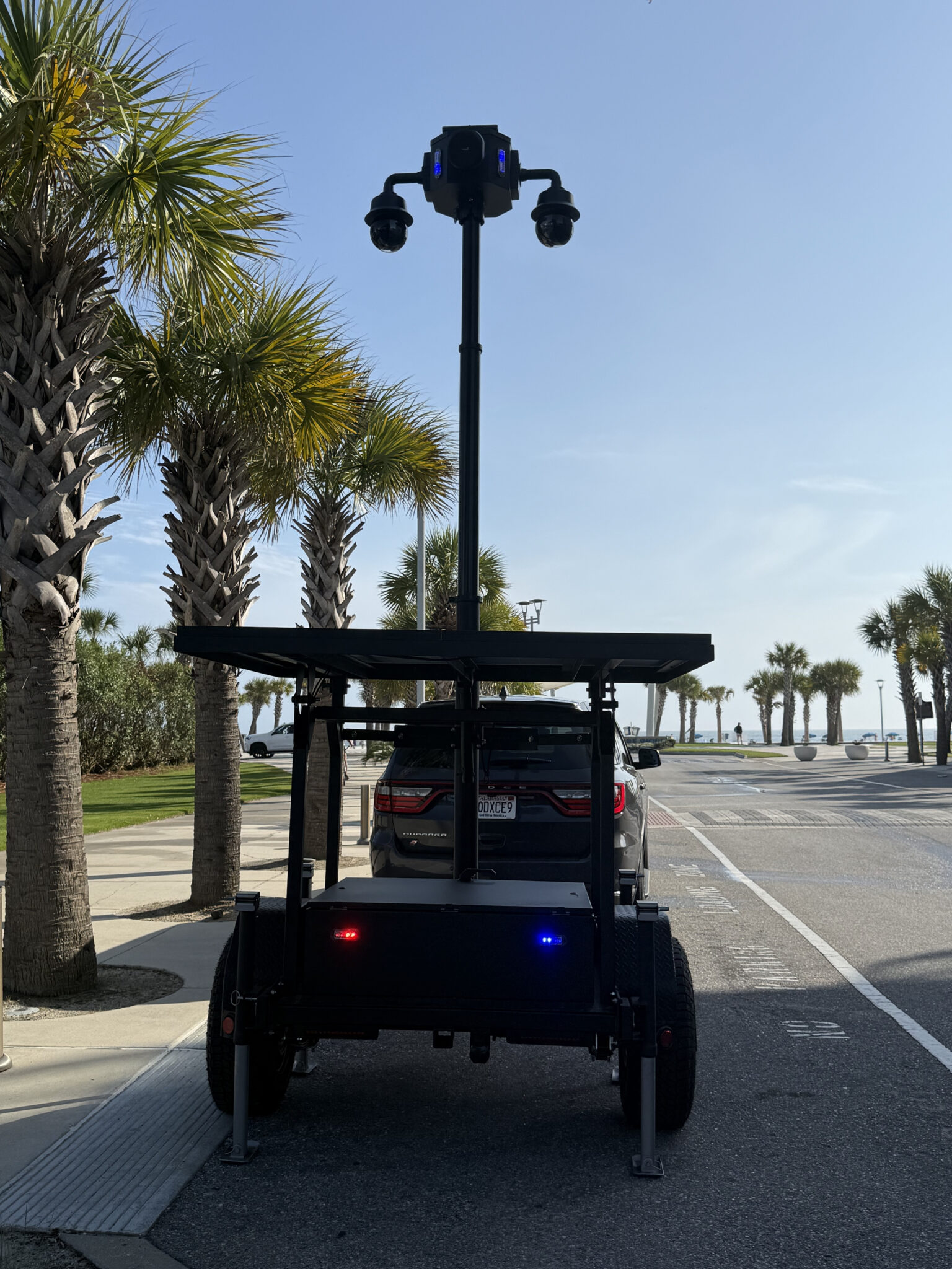 fxt-44-solar-surveillance-trailer-rear-deployment-lights-gulf-shores-police.jpg - Tech Deployments Made Simple by Critical Tech Solutions Rear view of CTS FXT-44 solar surveillance trailer with dual PTZ mast and emergency lights deployed by Gulf Shores Police Department for coastal public safety special event monitoring during spring break 2026