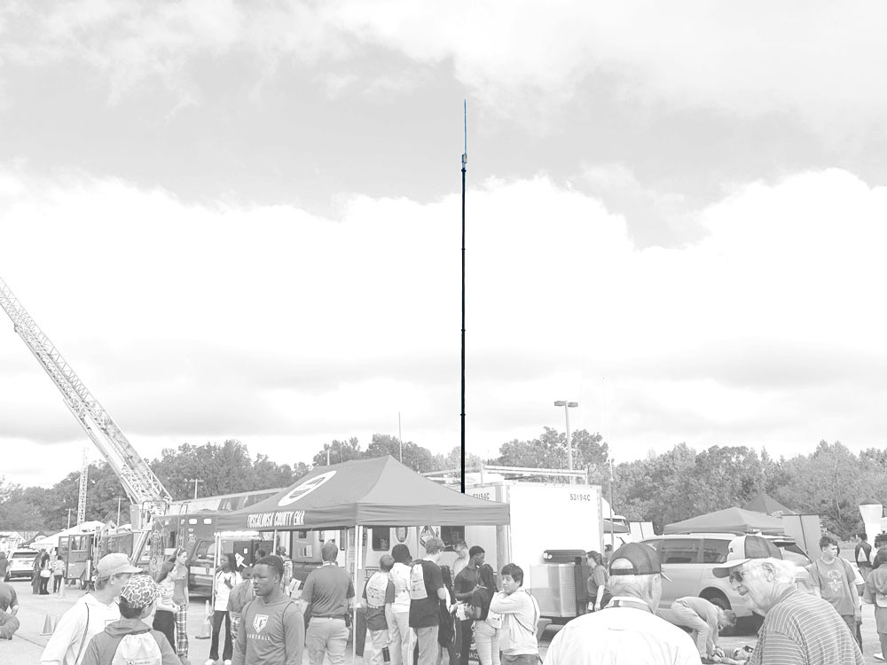 Wall-mounted telescopic mast with P25 antenna on law enforcement communications trailer